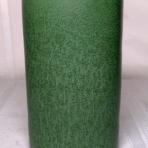 Puede incluir: Un jarrón de cerámica verde con una superficie texturizada.