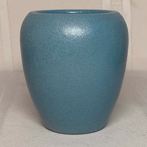 Könnte beinhalten: Eine hellblaue Keramikvase mit strukturierter Oberfläche.