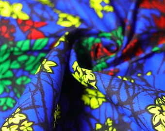 May include: A blue fabric with a colorful floral pattern. The fabric features yellow, green, and red flowers on a blue background.
