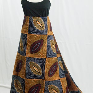 May include: A long, flowing skirt with a geometric pattern in shades of orange, brown, and blue. The skirt is made of a patterned fabric with a repeating design of stylized leaves.