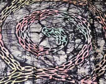Puede incluir: Tela batik negra y blanca con un patrón de cadenas rosadas, azules y amarillas en espiral.