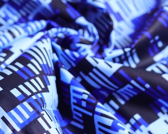 May include: Blue and black patterned fabric with a geometric design. The fabric is folded and textured.