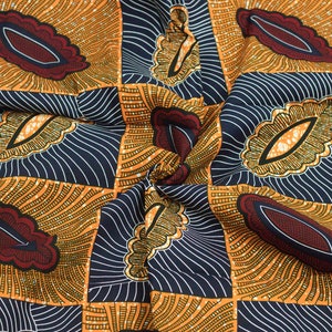 May include: A close-up of a fabric with a repeating pattern of orange, yellow, and blue geometric shapes. The fabric has a textured, woven look.