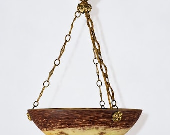 May include: A bowl-shaped pendant light fixture featuring a mottled brown and yellow glass shade suspended by three ornate gold-toned metal chains that connect to a decorative floral-shaped ceiling canopy at the top center point.