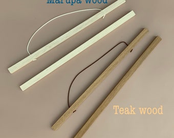 Puede incluir: Dos colgadores de póster de madera, uno de madera de marupa y otro de teca. Ambos colgadores tienen una cuerda para colgarlos.