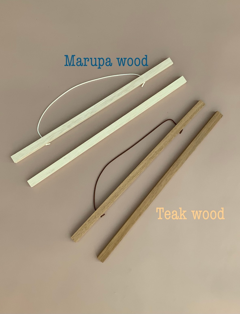 May include: Two sets of wooden poster hangers. The top set is labeled Marupa wood and features light-colored wood with a white cord. The bottom set is labeled Teak wood and features medium-brown wood with a dark brown cord.