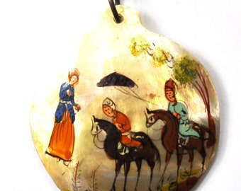 May include: A hand-painted, oval-shaped pendant with a scene of figures on horseback and a person standing. The pendant has a metal loop at the top. The figures are dressed in colorful clothing, and the background is a light, textured color.