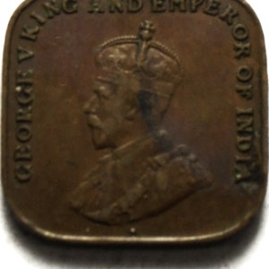 May include: A bronze coin with a profile of King George V, wearing a crown, and the text "GEORGE V KING AND EMPEROR OF INDIA".