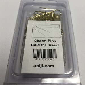 May include: A clear plastic package containing a large quantity of gold-colored charm pins. The package has a white label with the text "Charm Pins Gold for Insert" and a barcode with the number "011107297347". The label also includes the website "aniji.com".