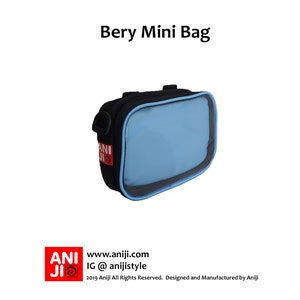 May include: A black and blue mini bag with a clear plastic window. The bag has a strap and the text "ANI" is printed on the front.