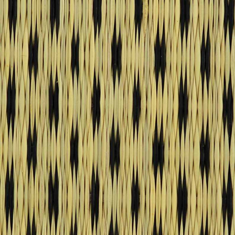 May include: Close-up of a woven mat with a black and beige diamond pattern.