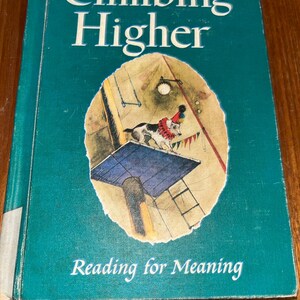 May include: A vintage book titled "Climbing Higher" with the subtitle "Reading for Meaning." The cover is teal with white text and a colorful illustration of a dog in a circus setting. The book appears to be in good condition.