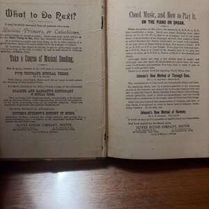 May include: Open book pages with text about music theory and instruction. The left page has the title "What to Do Next?" and the right page has "Chord Music, and How to Play It." The book is old with aged paper.