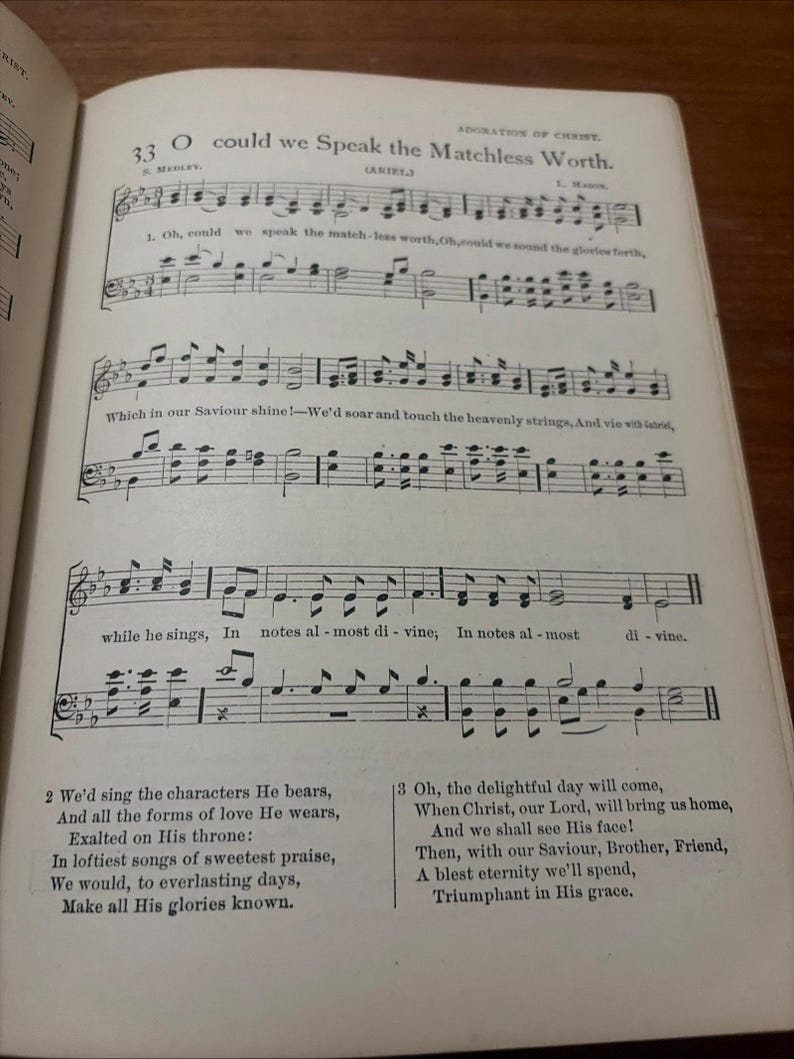 May include: Open book page with musical notation and lyrics. The text reads "O could we Speak the Matchless Worth." The page is aged with visible wear and tear, suggesting it is an antique or vintage item.