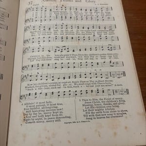 May include: Open book displaying sheet music with the title "Alleluia! Thanks and Glory." The page features musical notation, lyrics, and the number 37 at the top. The text includes phrases like "Children in the" and "Jesus Christ, the children's King."