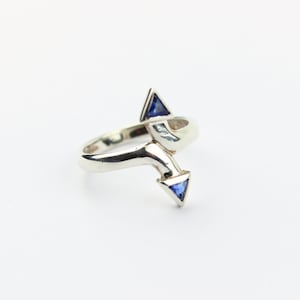 May include: A silver ring with a twisted band and two blue triangular gemstones.