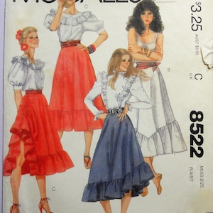 May include: A McCall's 8522 sewing pattern envelope featuring illustrations of three outfits. The designs include blouses with ruffled collars and long or puff sleeves paired with tiered skirts in red, white, and blue. Text includes McCall's 8522.