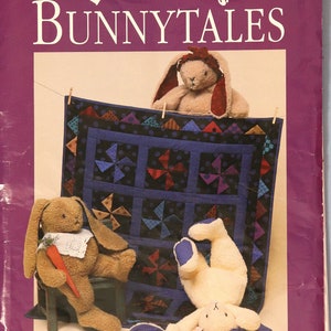 May include: A purple book cover with the title "Dream Spinners BUNNYTALES" and images of stuffed bunnies and a quilt. The quilt is blue with pinwheel designs. The text reads "Pattern for 20" bunny and 31 1/2" x 39" windmill quilt."