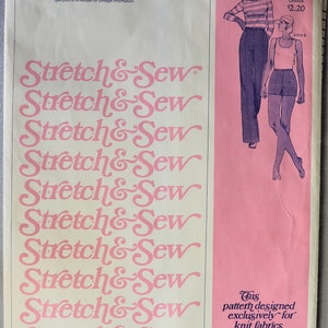May include: A vintage Stretch & Sew sewing pattern envelope for pants and shorts, pattern number 700. The cream-colored paper envelope features pink text and a pink side panel with illustrations of two figures wearing pants and shorts.