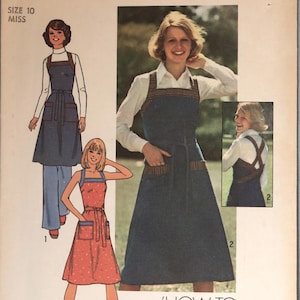 May include: Simplicity sewing pattern 7561 for a size 10 miss, featuring illustrations of a pinafore-style apron dress with pockets and a tie waist. The pattern includes a tissue lesson chart on tips on topstitching for two variations.