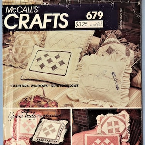 May include: A vintage McCall's Crafts 679 sewing pattern envelope for Cathedral Windows quilted pillows. The cover features various square and rectangular pillows with ruffled edges, quilted diamond patterns, and fabric textures in cream, pink, and brown tones.