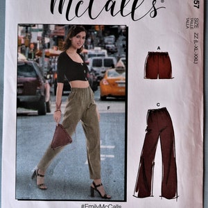 May include: McCall's M8057 sewing pattern envelope featuring a photograph of a person wearing a black cropped top and olive green trousers. The pattern includes illustrations for shorts labeled A and wide-leg trousers labeled C, in size ZZ.