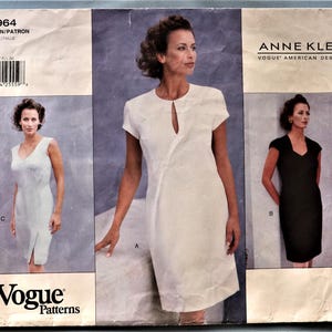 May include: A vintage Vogue sewing pattern featuring three Anne Klein dress designs. The pattern includes a white dress with a keyhole neckline, a sleeveless light-colored dress, and a black dress with a V-neckline. The pattern number is 1964.
