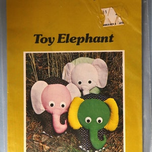 May include: A yellow package with the text "A Patchwork Pattern and Instructions by Yours Truly" and "Toy Elephant." The image shows three colorful toy elephants. Finished size is approximately 20" high.