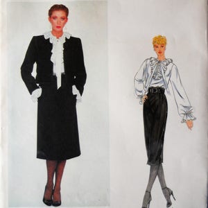 May include: A Vogue Paris Original sewing pattern envelope 2338 by Yves Saint Laurent. The cover features a photograph and an illustration of a black jacket and skirt ensemble paired with a white ruffled blouse. The text reads VOGUE PARIS ORIGINAL.
