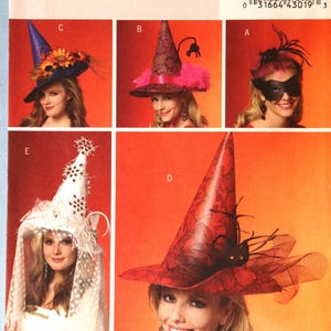 May include: Butterick B5406 sewing pattern envelope featuring five variations of pointed hats. The designs include a blue hat with sunflowers, a pink patterned hat with a spider, a black mask, a white hat with netting, and a red patterned hat with a spider.