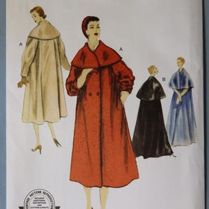 May include: Vogue Patterns V1977 sewing pattern envelope for a coat and cape design. The front displays illustrations of a long red coat with a wide collar, a beige coat, a black cape, and a blue cape. Text includes V1977, Vogue Patterns, and Reissue Circa 1955 Design.