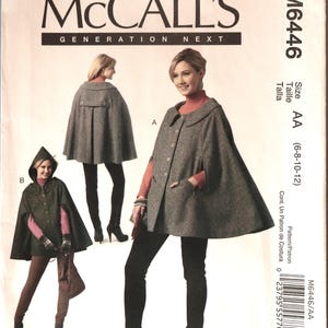 May include: McCall's sewing pattern M6446 for a cape in size AA (6-8-10-12). The envelope features illustrations of a grey button-front cape with a collar and a dark green hooded cape with buttons. The text includes the brand name and pattern number.
