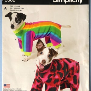 May include: A Simplicity sewing pattern envelope 8008 for dog clothing. The cover features two dogs wearing fleece jumpsuits: one with a rainbow stripe pattern and another with a pink and black leopard print. Text includes It's So Easy and Simplicity.