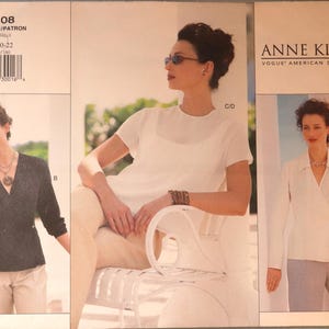 May include: An Anne Klein Vogue American Designer sewing pattern envelope 2308, size 18-20-22. The cover displays three garment variations: a dark gray wrap top, a white short-sleeved top, and a white long-sleeved wrap shirt with a collar.