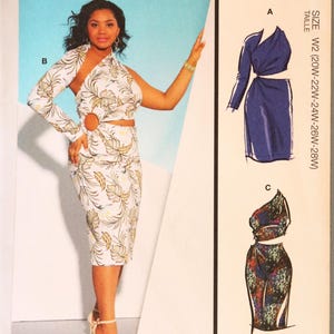 May include: McCall's sewing pattern M8331 for a dress with multiple views. The envelope features a white dress with a tropical leaf print, a single long sleeve, a circular cutout at the waist, and two additional illustrated design options.