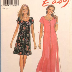 May include: New Look Easy sewing pattern 6359 for sizes 8-18. The envelope features illustrations of two dress variations: a short black dress with a multi-colored floral print and a long solid pink dress, both with short sleeves and button fronts.
