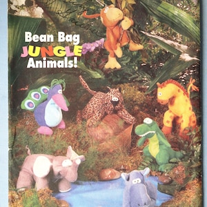 May include: A vintage Butterick pattern envelope featuring bean bag jungle animals. The cover displays various stuffed animal designs, including a giraffe, leopard, elephant, and crocodile, set against a jungle backdrop. The text reads "Bean Bag JUNGLE Animals!"