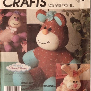 May include: McCall's Crafts pattern 3211 for stuffed animals from The Land of Pleasant Dreams. The envelope features illustrations of a brown bear with blue accents, a pink and tan lamb, and a plaid rabbit, all with stitched facial features.