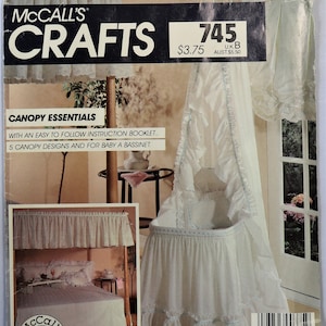 May include: A McCall's Crafts pattern for canopy essentials. The pattern features a white baby bassinet with a ruffled skirt and canopy, trimmed with blue accents. The pattern includes an instruction booklet with five canopy designs.