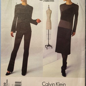 May include: A Vogue Patterns sewing pattern envelope for Calvin Klein designs, featuring two outfits: a long-sleeved top with flared pants and a color-blocked midi dress. The envelope displays the pattern number 2002, size 8-10-12, and a barcode.
