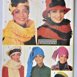 May include: A Butterick 4756 sewing pattern envelope featuring illustrations of various hats and scarves. Designs include a yellow hat with a black bow, a red hat with a black bow, a cream beret, a blue long-tailed hat, a pink hat, and a green hat.