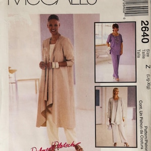 May include: A white ceramic mug with a black handle and the text "But First, Coffee" in a black, handwritten-style font. The mug is on a white surface.