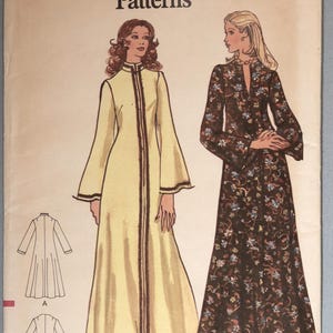 May include: A Very Easy Vogue Patterns sewing pattern envelope 8446, size Medium. The front displays illustrations of two floor-length dresses: one solid light yellow with dark trim and one dark brown with a multi-colored floral print pattern.