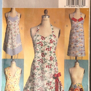 May include: A vintage Butterick sewing pattern, B4945, featuring apron designs. The aprons showcase various patterns, including floral, cherry, and dessert motifs. The pattern includes sizes small to large.