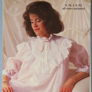 May include: A vintage advertisement for a nursing gown. The pink gown features a ruffled collar and sleeves with lace trim. The text reads "A Beautiful Nursing Gown" and includes size options.