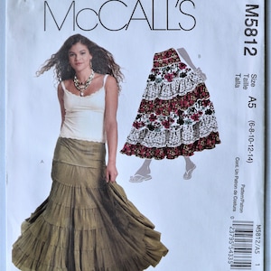 May include: McCall's M5812 sewing pattern envelope featuring a tiered olive green skirt and a floral tiered skirt option. The white paper envelope displays the pattern number M5812, size range A5 (6-8-10-12-14), and includes a barcode and text.