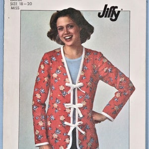 May include: A Simplicity 7956 Jiffy sewing pattern envelope for a jacket in size large 18-20. The jacket is red with a blue and yellow floral print, featuring white trim along the edges and three white ribbon bows as front closures.