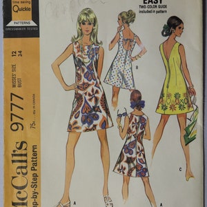 May include: Vintage McCall's sewing pattern 9777 for misses' dresses with three back styles. The pattern features illustrations of dresses with various prints and designs. The package includes a two-color guide and is marked as "Quickie" and "Easy".