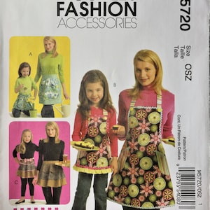 May include: McCall's Fashion Accessories sewing pattern M5720 for aprons. The envelope features illustrations of children and adults wearing floral print aprons and tiered ruffle aprons. Text includes McCall's Fashion Accessories, M5720, and Size OSZ.