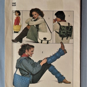 May include: A Simplicity sewing pattern envelope 8146 featuring illustrations of three different bag styles and quilted leg warmers. The pattern includes a yellow woven shoulder bag, a white messenger bag, a camouflage backpack, and blue quilted leg warmers.